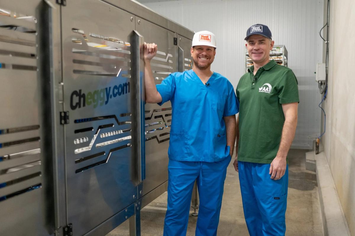 Jasen Urena (left), Vice President of NestFresh Eggs and Jörg Hurlin (right), Managing Director of AAT are pictured with the first in-ovo sex determining machine, Cheggy, in the United States at an Iowa hatchery. Courtesy of streamcommunications.